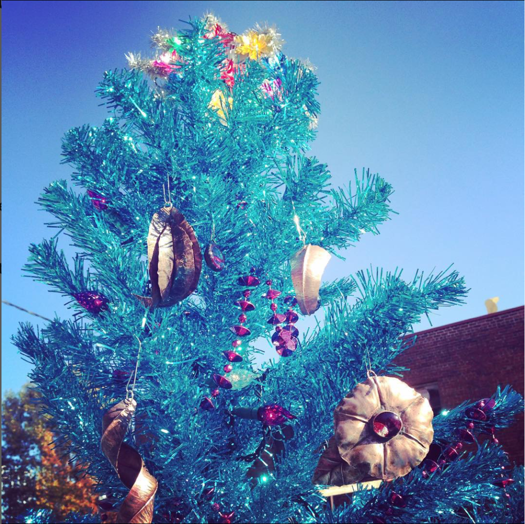 film-style distortion on cropped photo of a teal-blue tinsel christmas tree with copper ornaments